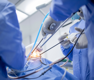 Surgeon performing minimally invasive spine surgery through a small incision using an endoscope